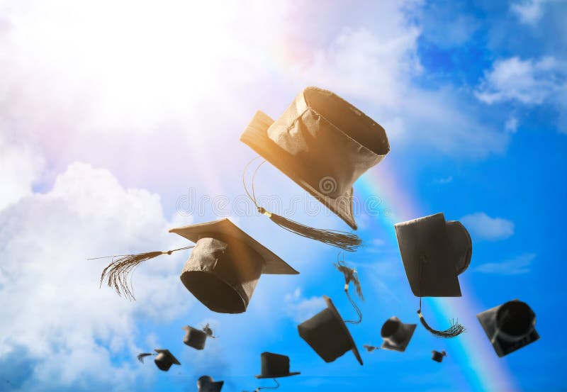 Graduation caps, hat thrown in the air with sun ray blue sky abs