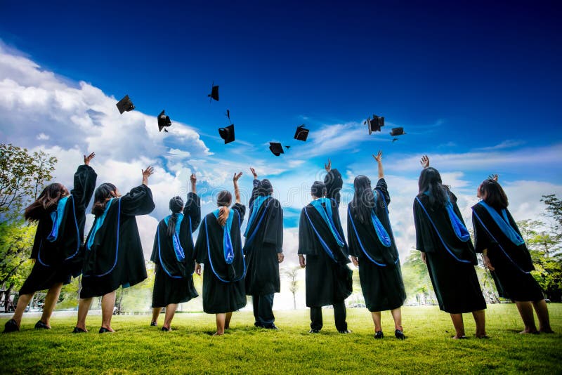 Group of graduates with congratulations throwing graduation hats in the air celebrating.