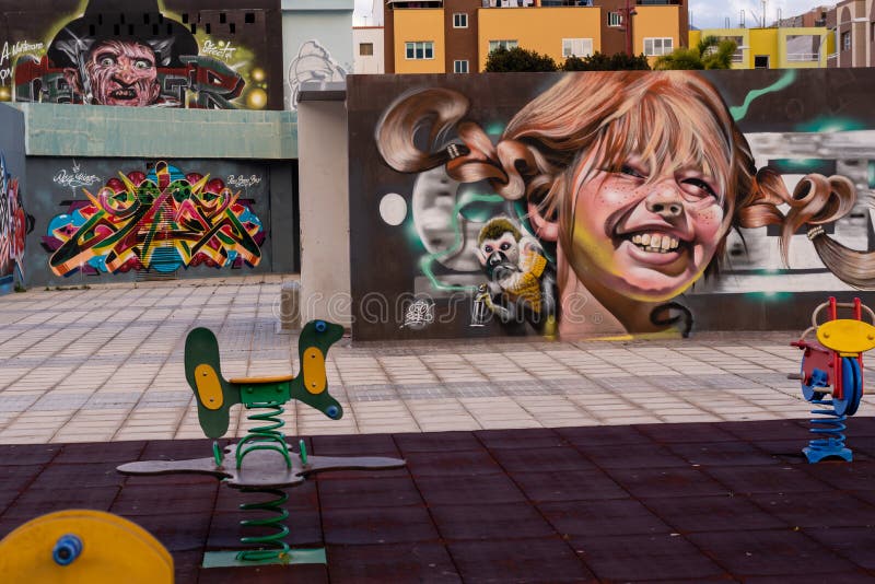 Fabulous Graffiti art smiling girl in the foreground and sea pirate in the background walls in a children park in Gran Canaria, Spain. Fabulous Graffiti art smiling girl in the foreground and sea pirate in the background walls in a children park in Gran Canaria, Spain.