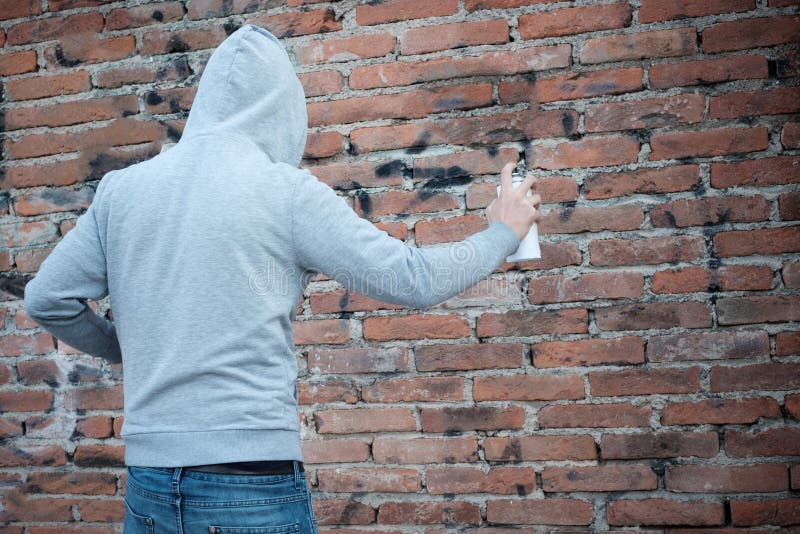 Graffiti incappucciati di scrittura di tagger sulle pareti urbane fotografia stock libera da diritti Graffiti incappucciati di scrittura di tagger sulle pareti urbane fotografia stock libera da diritti