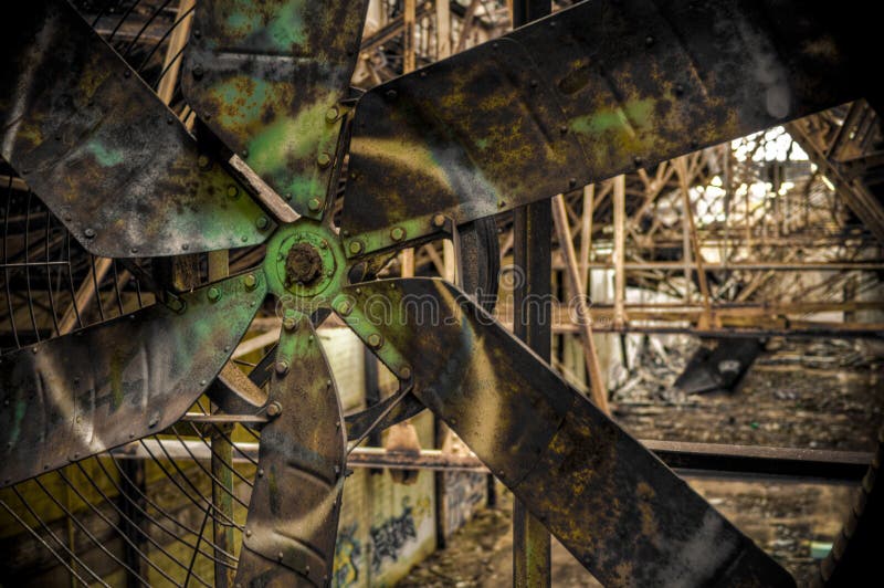 Immagine con messa a fuoco su un grande ventilatore in una fabbrica abbandonata di magazzino coperto di graffiti di vernice.