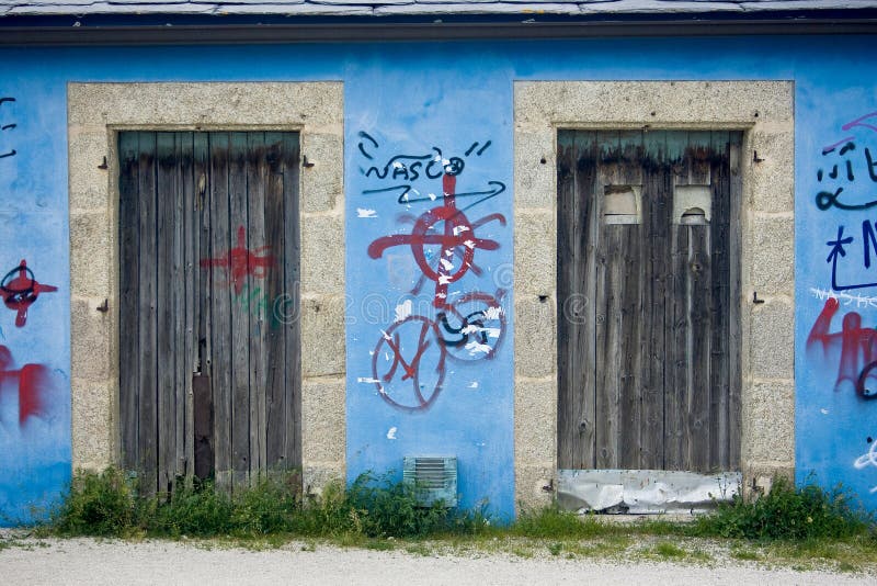 Graffiti and rustic doors on a blue wall