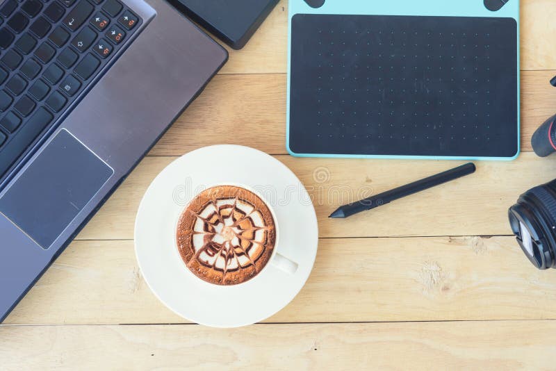 Grafische computer en cameraapparaat met hete cappuccinokoffie stock afbeelding Grafische computer en cameraapparaat met hete cappuccinokoffie stock afbeelding