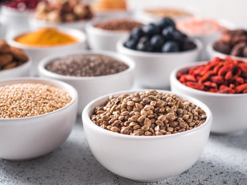 Graines de chanvre dans la petite cuvette blanche et tout autre superfood image libre de droits Graines de chanvre dans la petite cuvette blanche et tout autre superfood image libre de droits