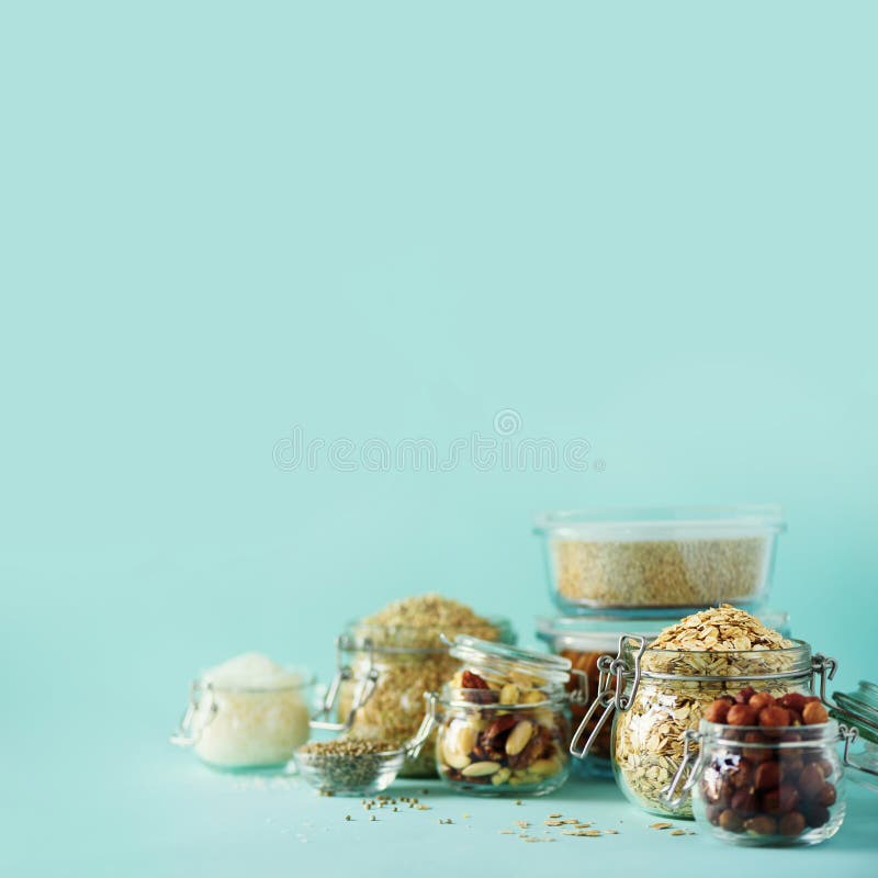Grains, cereals, nut, dry fruits in glass jars over blue background with copy space. Clean eating, healthy, vegan diet concept royalty free stock photography Grains, cereals, nut, dry fruits in glass jars over blue background with copy space. Clean eating, healthy, vegan diet concept royalty free stock photography