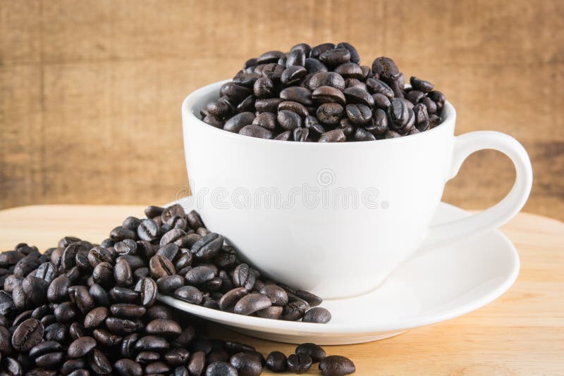 Grains de café dans la tasse blanche images libres de droits Grains de café dans la tasse blanche images libres de droits