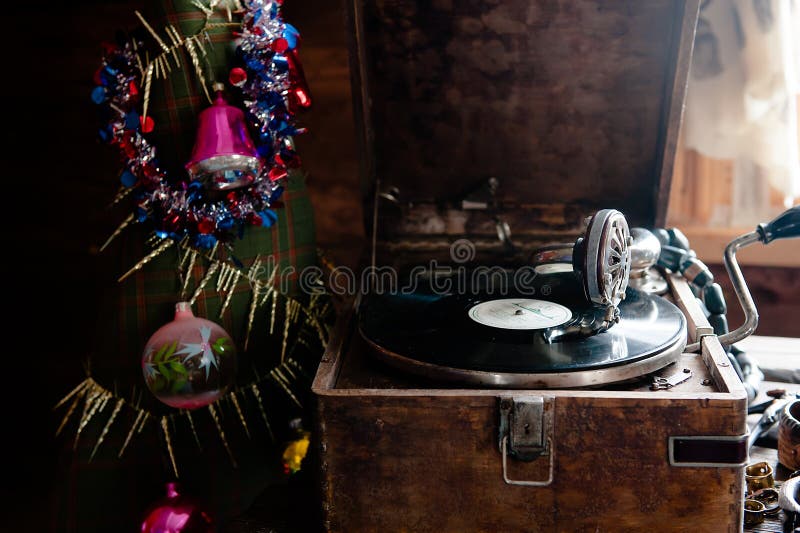 Image of Christmas. Gramophone playing a record. Gramophone with a vinyl record on a background of Christmas decorations, cap, Christmas tree and bright lights. Bright red hat stock images, royalty-free photos and pictures