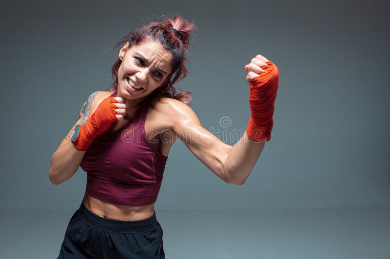 Retrato De Una Mujer Luchadora En Vendas De Boxeo Parada En Un Estudio  Aislado De Fondo Gris Imagen de archivo - Imagen de atractivo, muscular:  194490929
