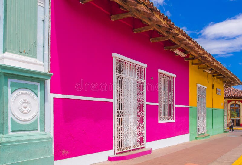 GRANADA, NICARAGUA, MAY, 14, 2018: Outdoor view of facade buildings with pink wall, wooden door and roof in a gorgeous