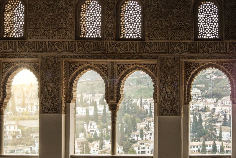 GRANADA, SPAIN - FEBRUARY 10, 2015: A view to old white houses of Granada through a window decorated with calligraphy