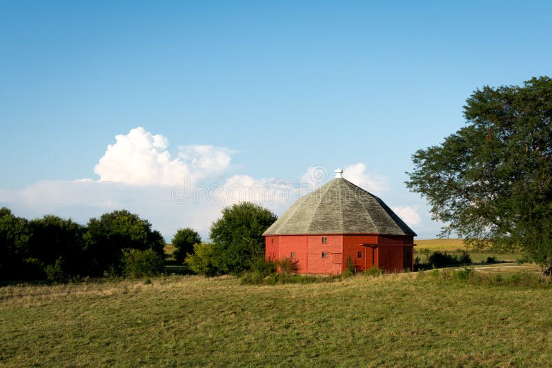 Granaio rosso rotondo unico circondato da terreno coltivabile aperto in Illinois rurale immagini stock