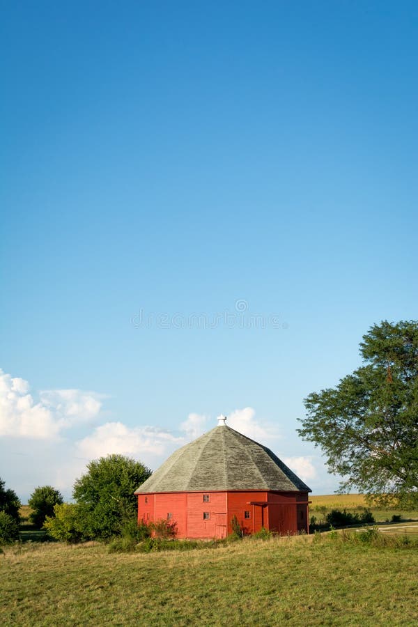 Granaio rosso rotondo unico circondato da terreno coltivabile aperto in Illinois rurale fotografie stock