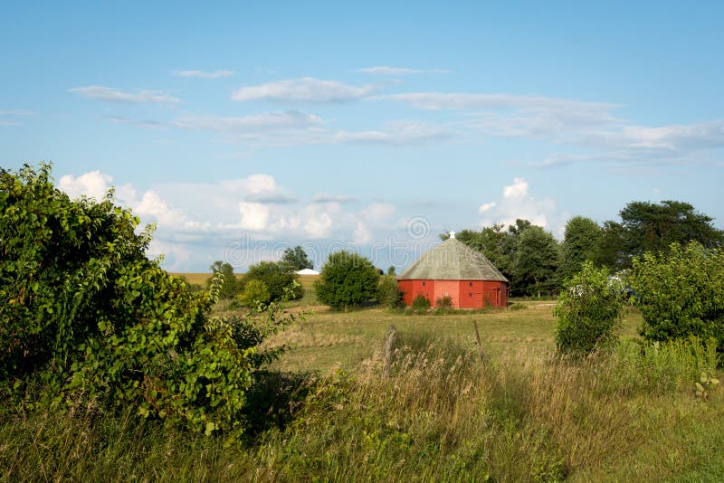 Granaio rosso rotondo unico circondato da terreno coltivabile aperto in Illinois rurale fotografie stock libere da diritti