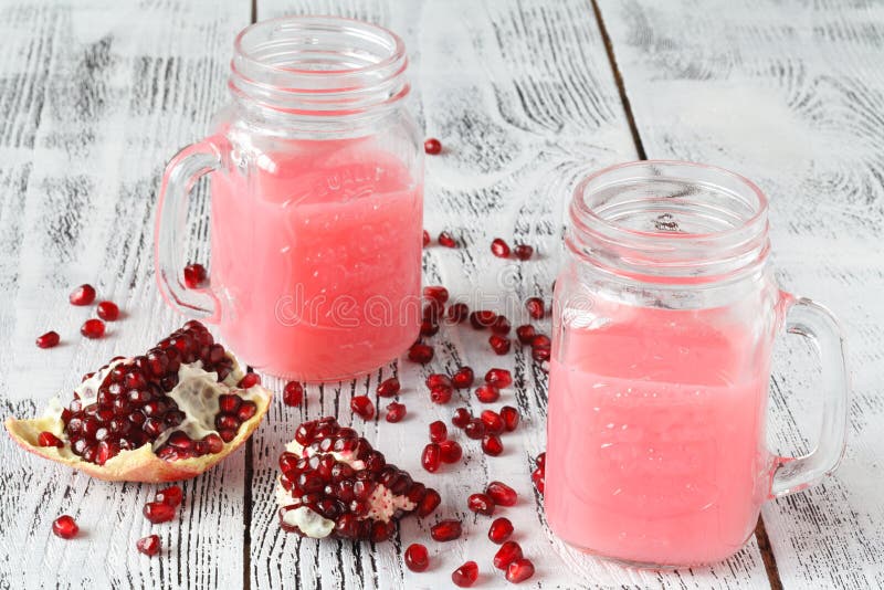 Granatowa smoothie w słoju szkle z granatowów kawałkami, sce obraz royalty free Granatowa smoothie w słoju szkle z granatowów kawałkami, sce obraz royalty free