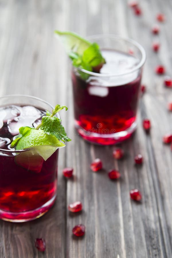 Granatäpplecoctail med den granatäpplefrö, limefrukt och mintkaramellen Alkoholist och icke-alkoholist fotografering för bildbyråer Granatäpplecoctail med den granatäpplefrö, limefrukt och mintkaramellen Alkoholist och icke-alkoholist fotografering för bildbyråer