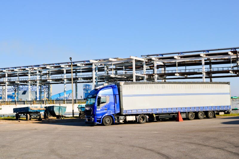 Grand camion bleu avec la cabine et la remorque à l'ensemble industriel dessus photo stock Grand camion bleu avec la cabine et la remorque à l'ensemble industriel dessus photo stock