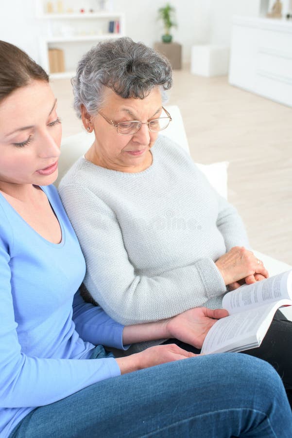 Grand daughter reading book to grandma