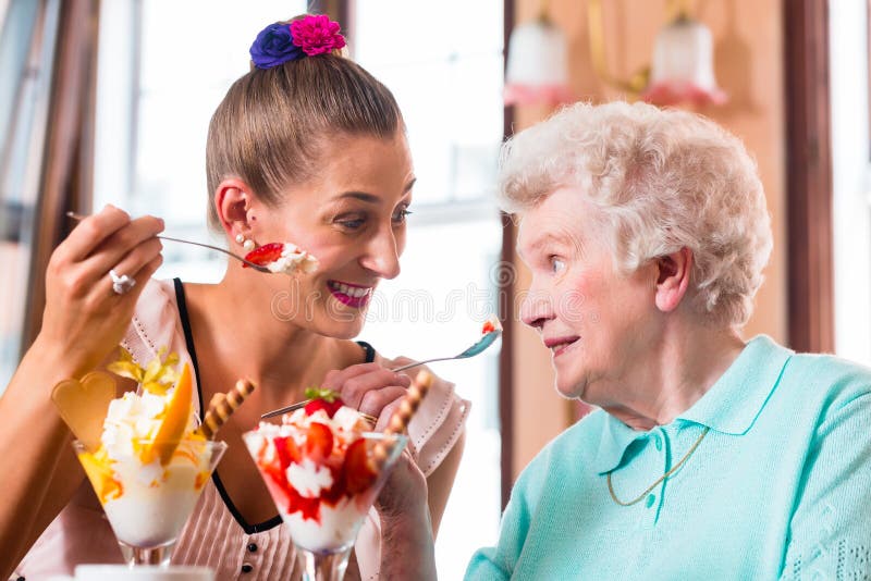 Grand-mère et jeune femme mangeant la crème glacée photographie stock libre de droits Grand-mère et jeune femme mangeant la crème glacée photographie stock libre de droits
