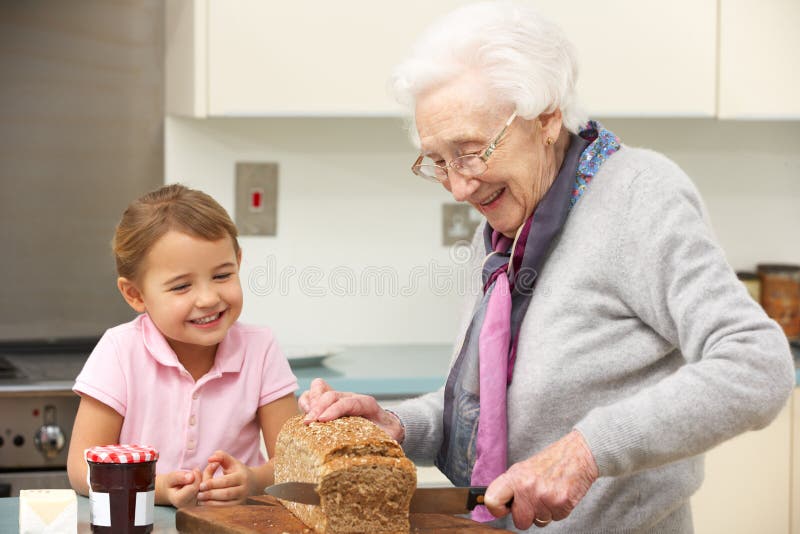 Grand-mère et petite-fille préparant la nourriture image stock Grand-mère et petite-fille préparant la nourriture image stock
