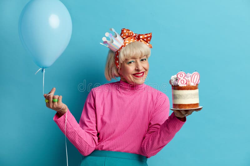 Grand-mère heureuse fêtant son anniversaire. dame avec gâteau et ballon gonflé photographie stock