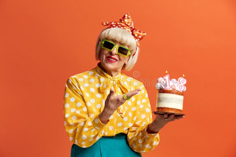 Grand-mère heureuse fêtant son anniversaire. dame tient le gâteau avec des bougies en feu photos stock