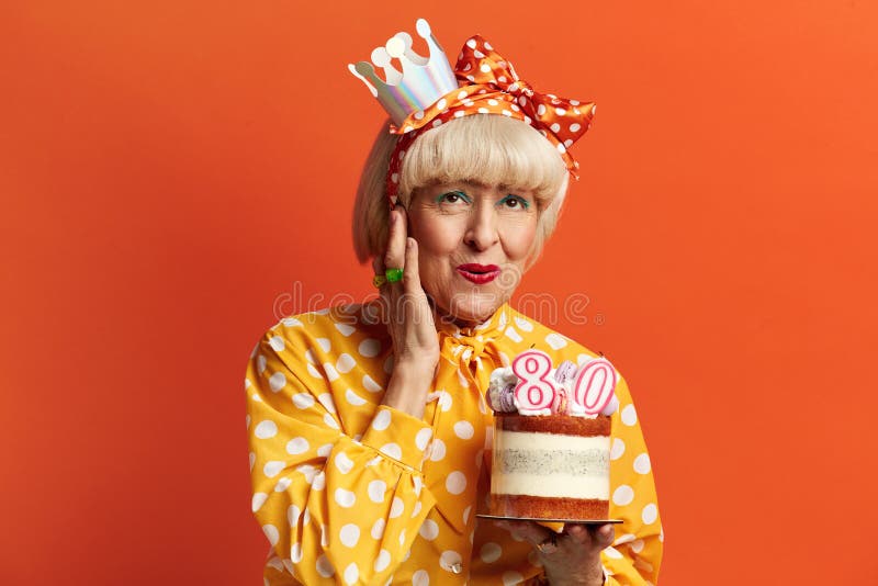 Grand-mère heureuse fêtant son anniversaire. dame tient le gâteau avec des bougies en feu images stock