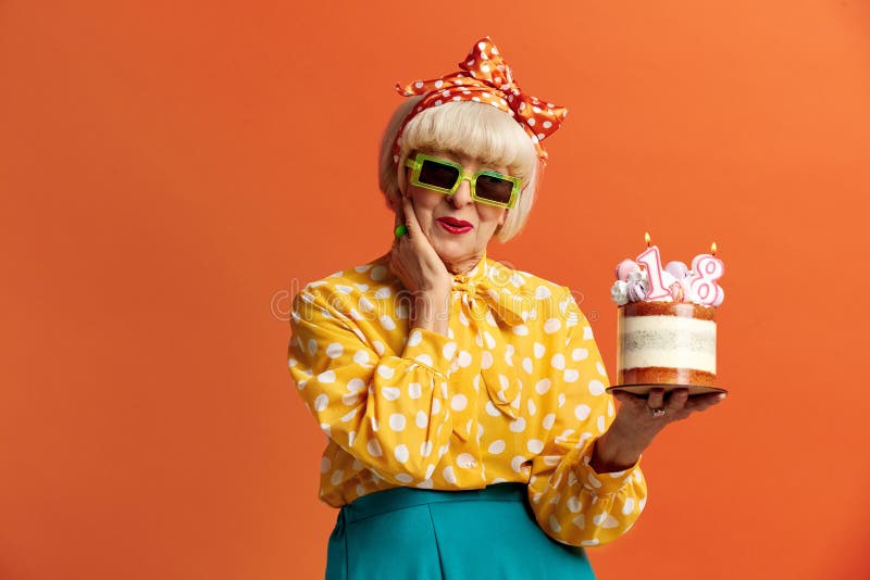 Grand-mère heureuse fêtant son anniversaire. dame tient le gâteau avec des bougies en feu photo stock