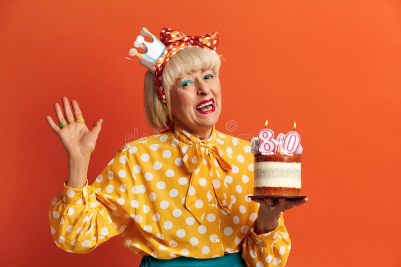 Grand-mère heureuse fêtant son anniversaire. dame tient le gâteau avec des bougies en feu photos stock