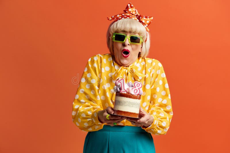 Grand-mère surprise fêtant son anniversaire. dame tient le gâteau avec des bougies en feu image stock
