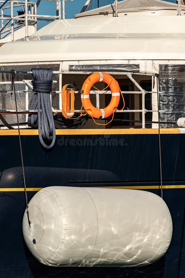 Close-up of a large white boat fender protecting the side of a yacht. Close-up of a large white boat fender protecting the side of a yacht