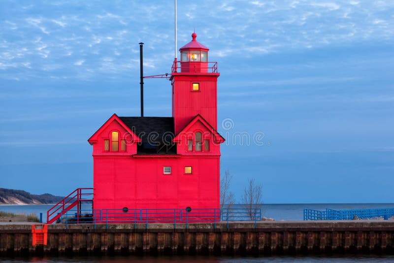 Holland Harbor Light, locally known as Big Red is starkley vivid in this early eveing scene. Lights glow golden from the windows as dusk settles softly on the shores of Lake Michigan. Holland Harbor Light, locally known as Big Red is starkley vivid in this early eveing scene. Lights glow golden from the windows as dusk settles softly on the shores of Lake Michigan