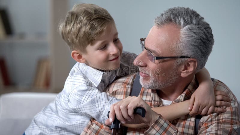 Grand-père de embrassement de petit-fils avec amour, minutes précieuses de famille, soin plus âgé photo libre de droits Grand-père de embrassement de petit-fils avec amour, minutes précieuses de famille, soin plus âgé photo libre de droits