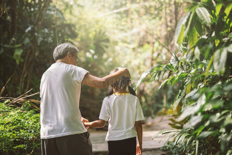 Grand-père de famille et promenade heureux de petite-fille sur la nature sur la main de prise de coucher du soleil photo libre de droits Grand-père de famille et promenade heureux de petite-fille sur la nature sur la main de prise de coucher du soleil photo libre de droits