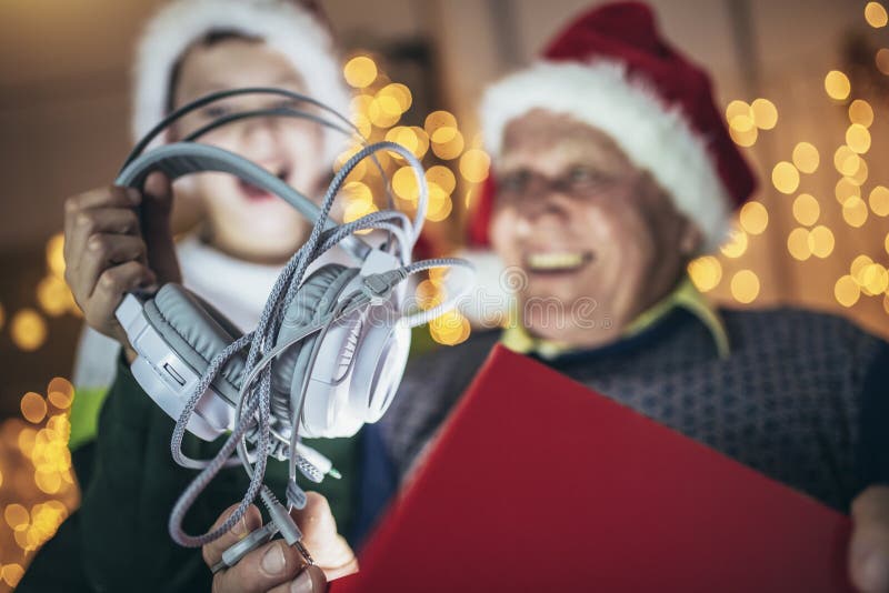 Grand-père et petit-fils assis sur la chaise avec des cadeaux pendant noël photos stock