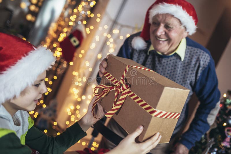 Grand-père et petit-fils avec cadeaux pendant noël images libres de droits