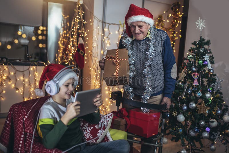 Grand-père et petit-fils avec cadeaux pendant noël images stock