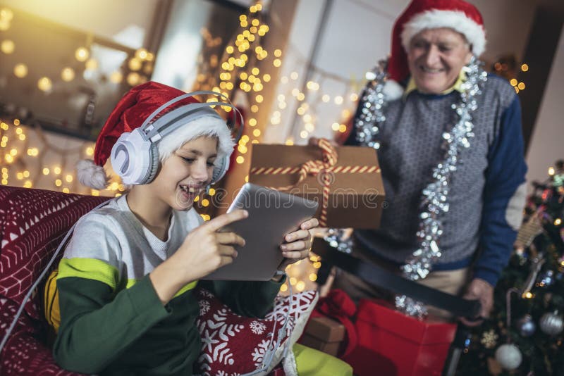 Grand-père et petit-fils avec cadeaux pendant noël images stock
