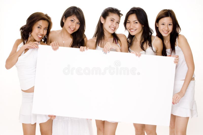 Five attractive young women in white hold a large blank sign. Five attractive young women in white hold a large blank sign