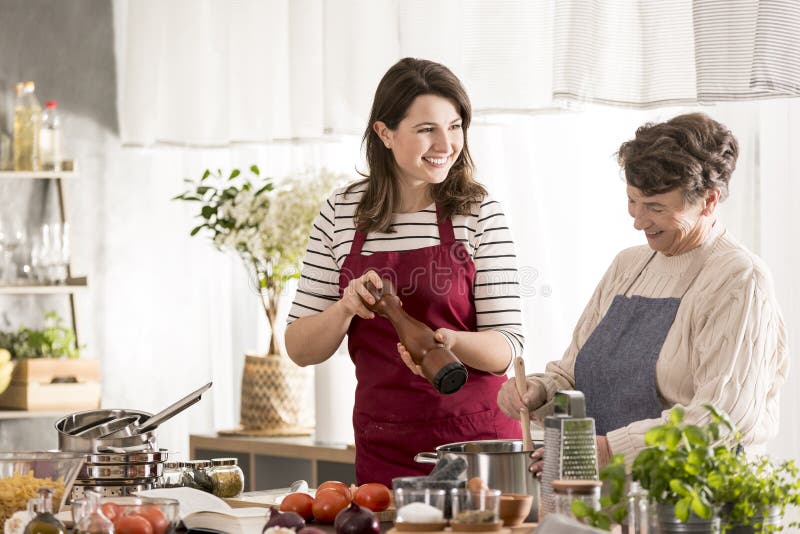 Granddaughter cooking dinner with grandma royalty free stock photo