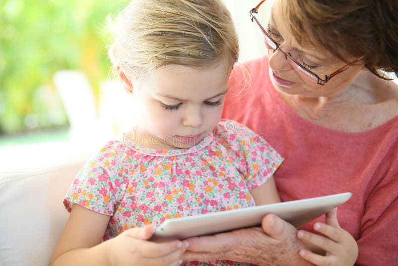 Granddaugter and her grandmother playing on a tablet