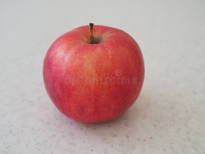 Grande Apple rosso ha isolato sulla tavola di marmo Fine in su fotografia stock Grande Apple rosso ha isolato sulla tavola di marmo Fine in su fotografia stock