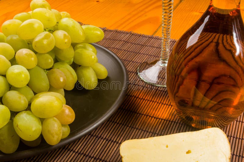 grande brosse des raisins verts dans un plat en c?ramique, un d?canteur et un verre de vin et de fromage images stock grande brosse des raisins verts dans un plat en c?ramique, un d?canteur et un verre de vin et de fromage images stock
