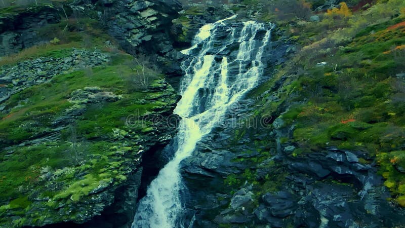 Grande cascade cascadant en bas d'un côté de la montagne escarpée banque de vidéos