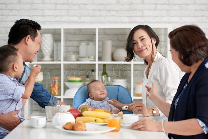 Grande famille asiatique prenant le petit déjeuner images libres de droits Grande famille asiatique prenant le petit déjeuner images libres de droits
