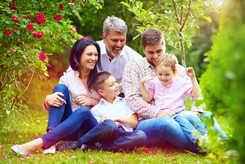 Grande famille heureuse ensemble dans le jardin d'été photos stock Grande famille heureuse ensemble dans le jardin d'été photos stock