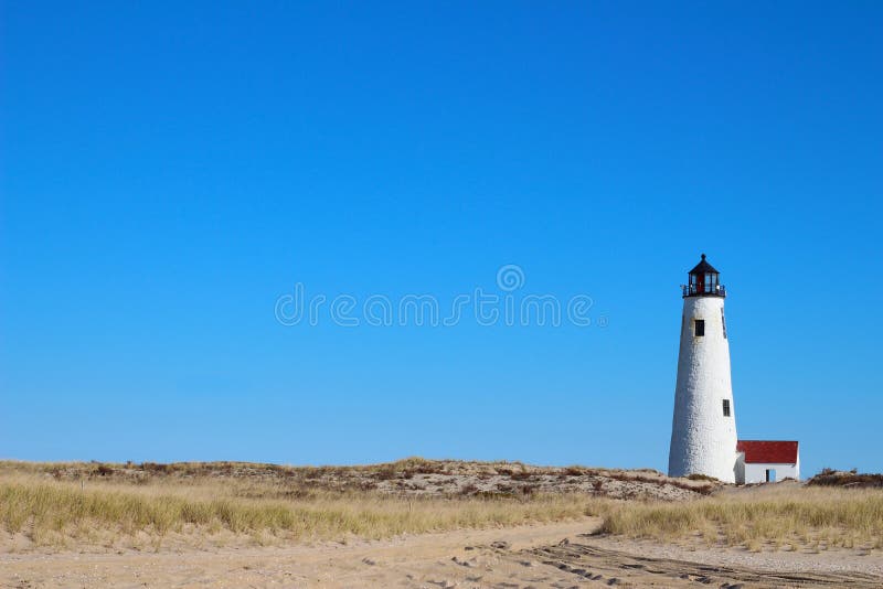 Grande farol Nantucket Massachusetts miliampère da luz do ponto com céu azul, junco e dunas e areia fotos de stock royalty free Grande farol Nantucket Massachusetts miliampère da luz do ponto com céu azul, junco e dunas e areia fotos de stock royalty free