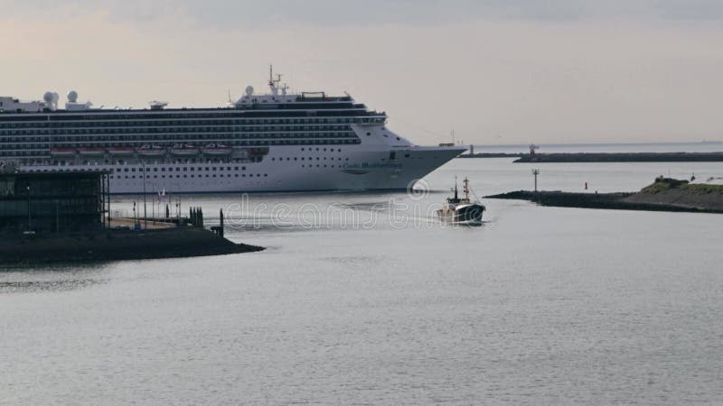 Grande navio de cruzeiro moderno que entra num porto fluvial