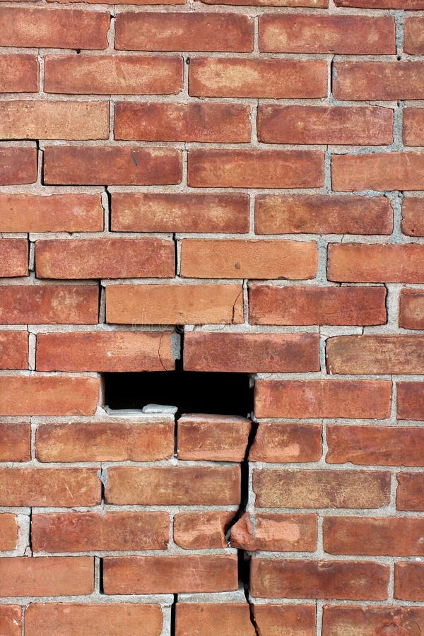 Grande parede de tijolo com necessidade do reparo, com quebras por toda parte e falta das seções fotografia de stock Grande parede de tijolo com necessidade do reparo, com quebras por toda parte e falta das seções fotografia de stock