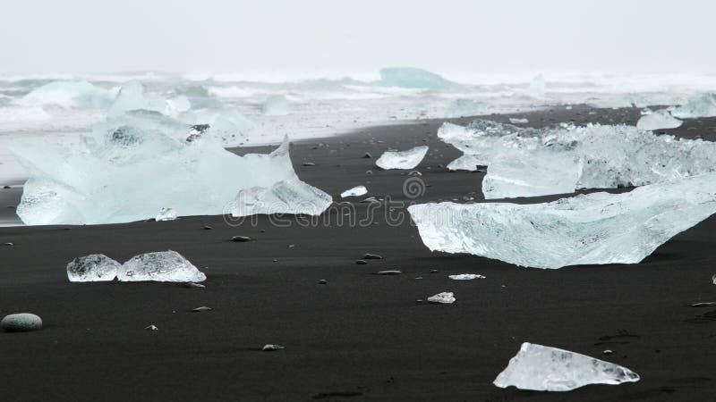 Grande pedaço de gelo e icebergue azul puro na praia de areia negra na islândia 8k 4 2 2 10 bits (log classificado)