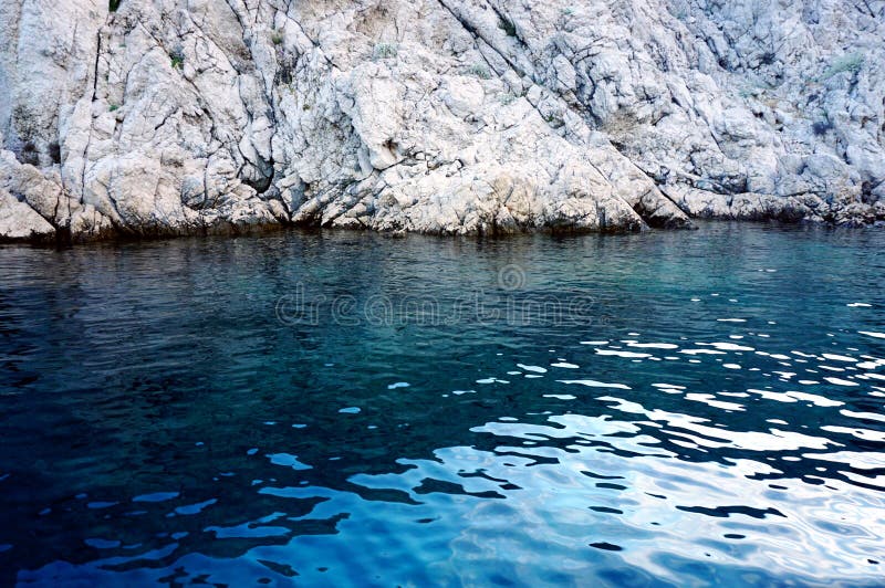 Grande pierre de mer comme le mur pierreux, immergé dans l'eau de mer bleue photos stock Grande pierre de mer comme le mur pierreux, immergé dans l'eau de mer bleue photos stock
